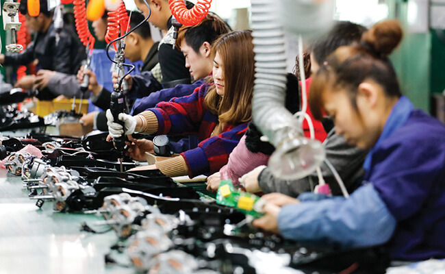 Factory workers in China. Will they be replaced by industrial robots?