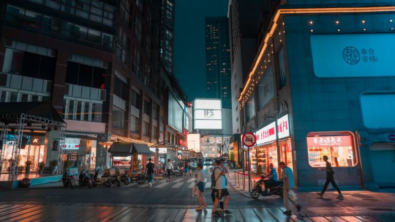 Shoppers and illuminated storefronts on a busy street in central Chengdu at night