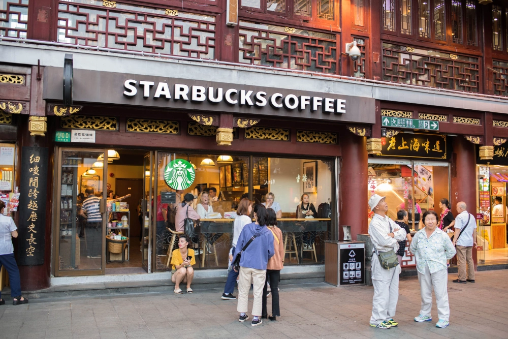 A Starbucks coffee shop with traditional Chinese architecture in Shanghai, representing the premium coffeehouse experience in China's coffee market.