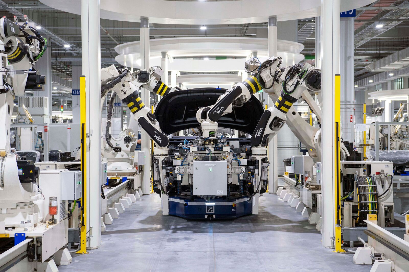 Robotic arms on a car assembly line in a factory
