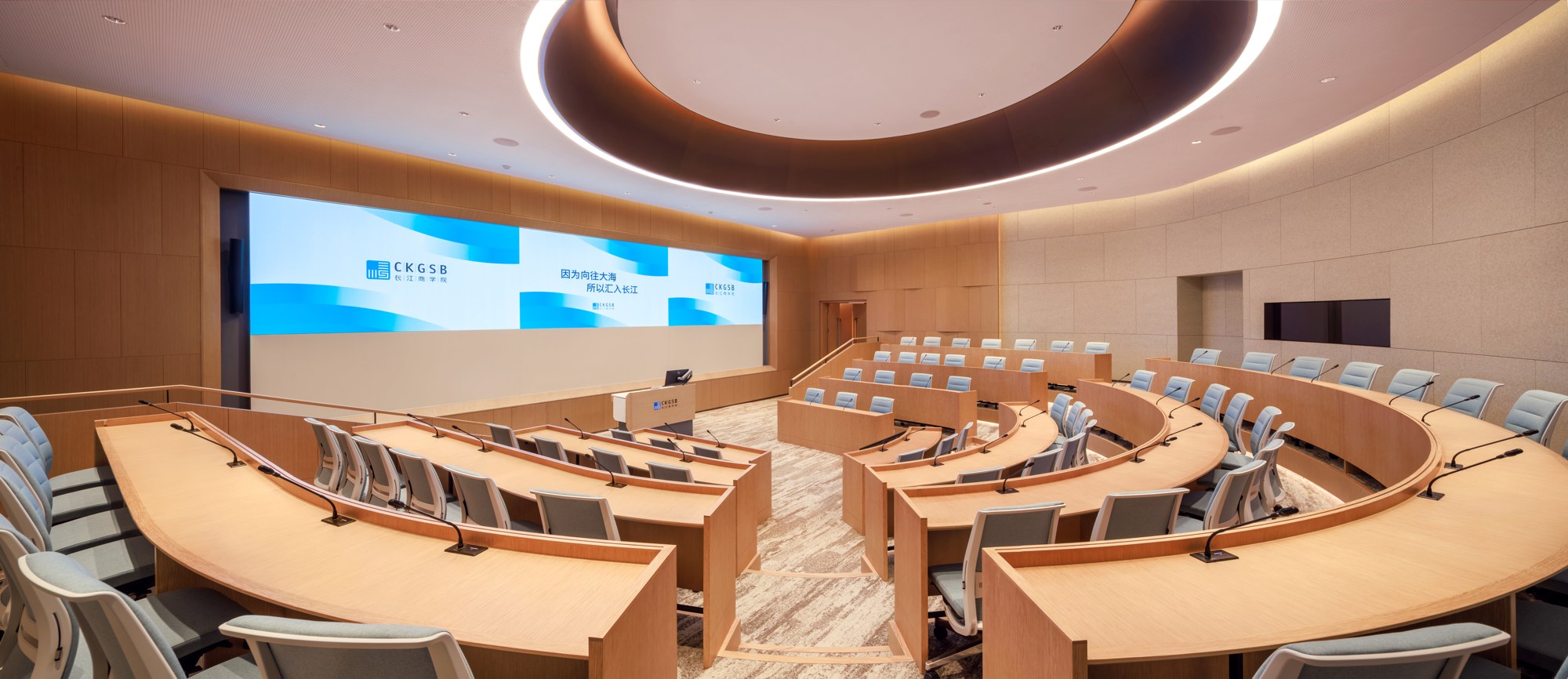 Tiered classroom with curved desks and a large teaching screen at CKGSB’s permanent Beijing campus